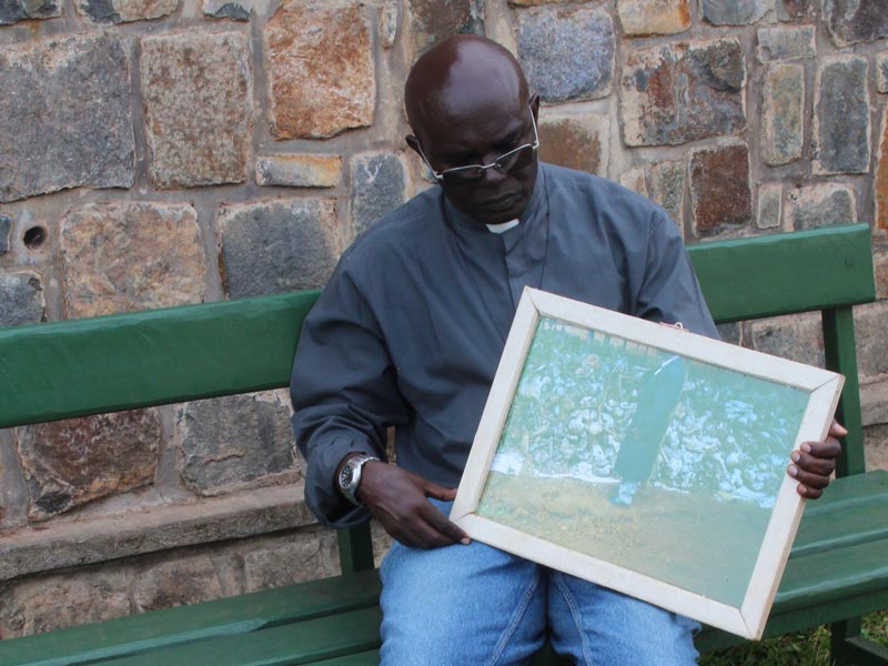 Father Ubald sitting with an framed picture