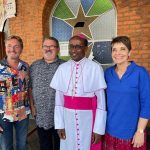 Bishop standing with speakers