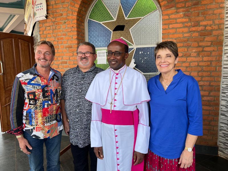 Bishop standing with speakers