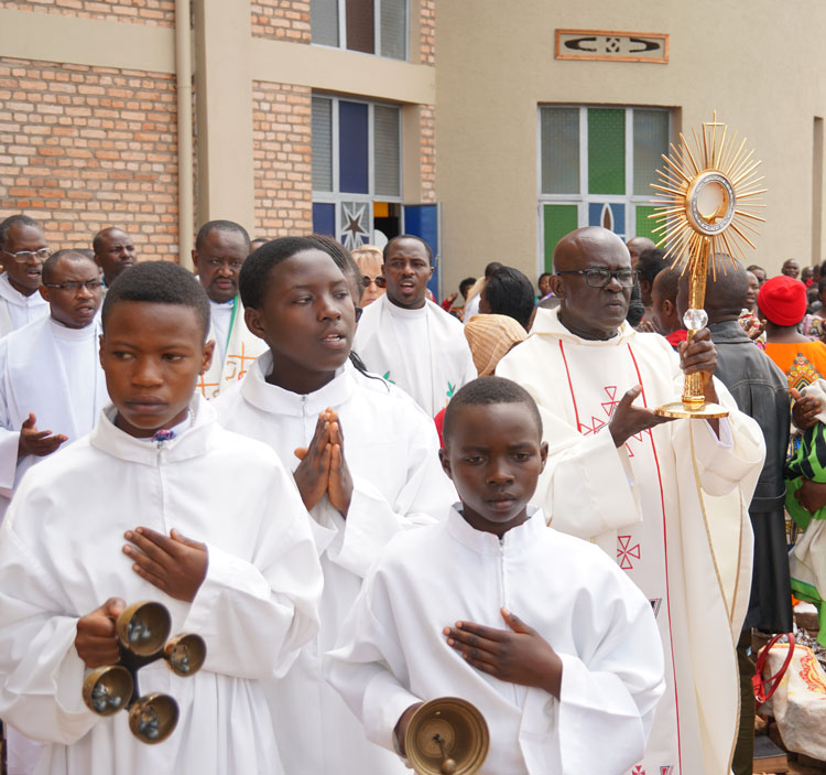 People standing outside a church with bells